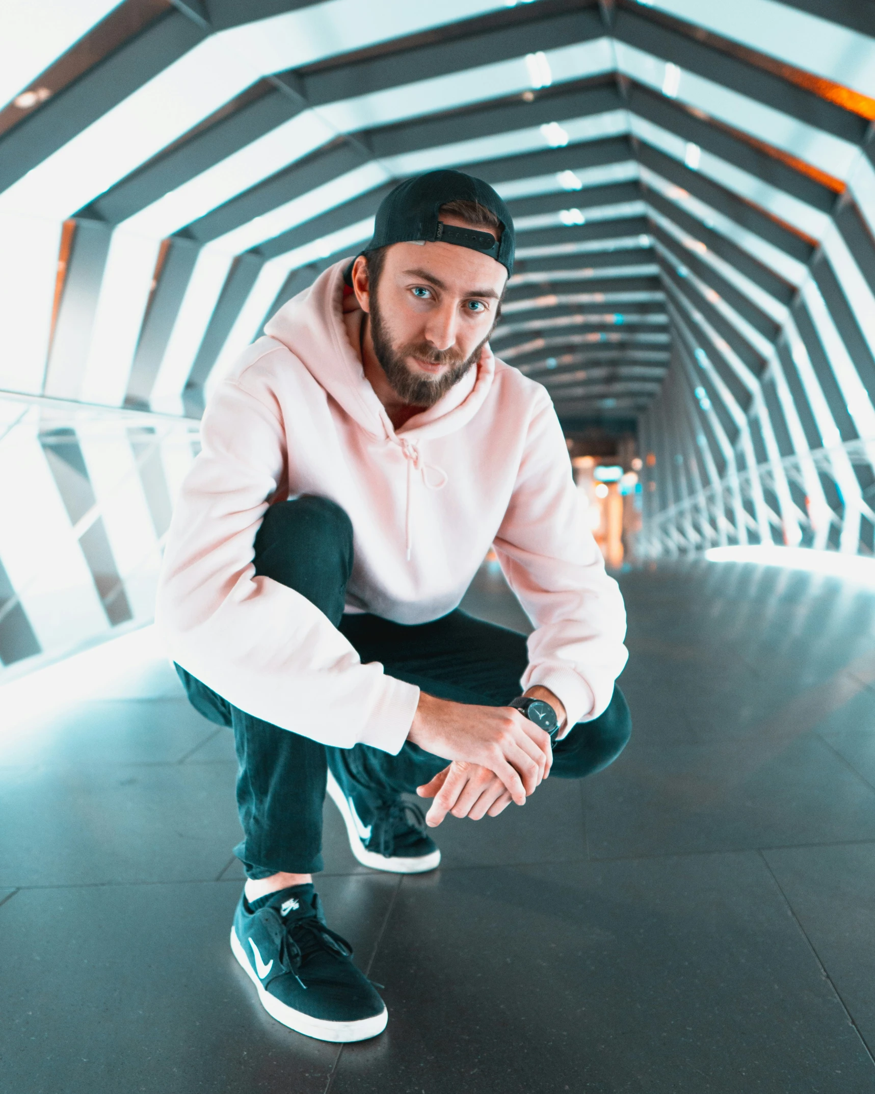 a man is squatting down in the air wearing a sweatshirt