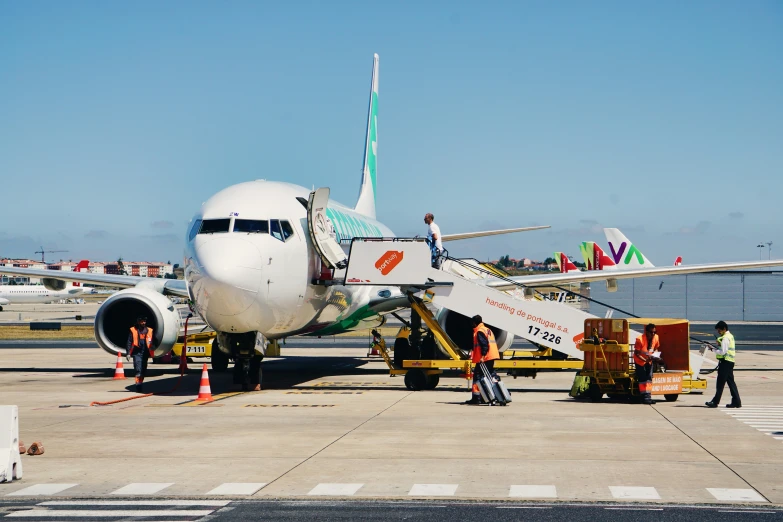 the airplane is being serviced by workers on the tarmac