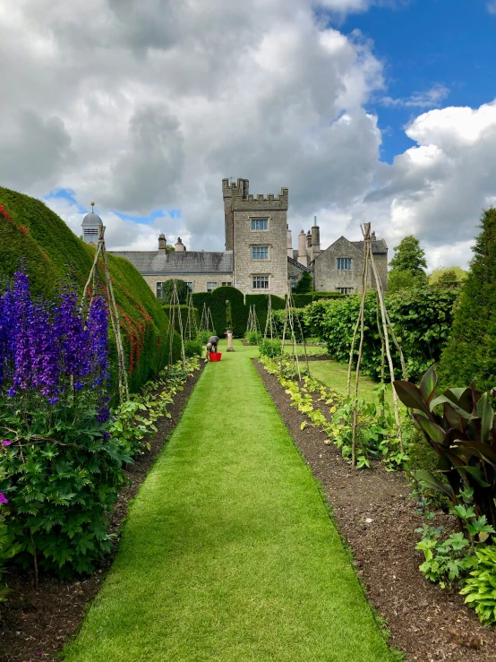 a path going to a large house surrounded by grass