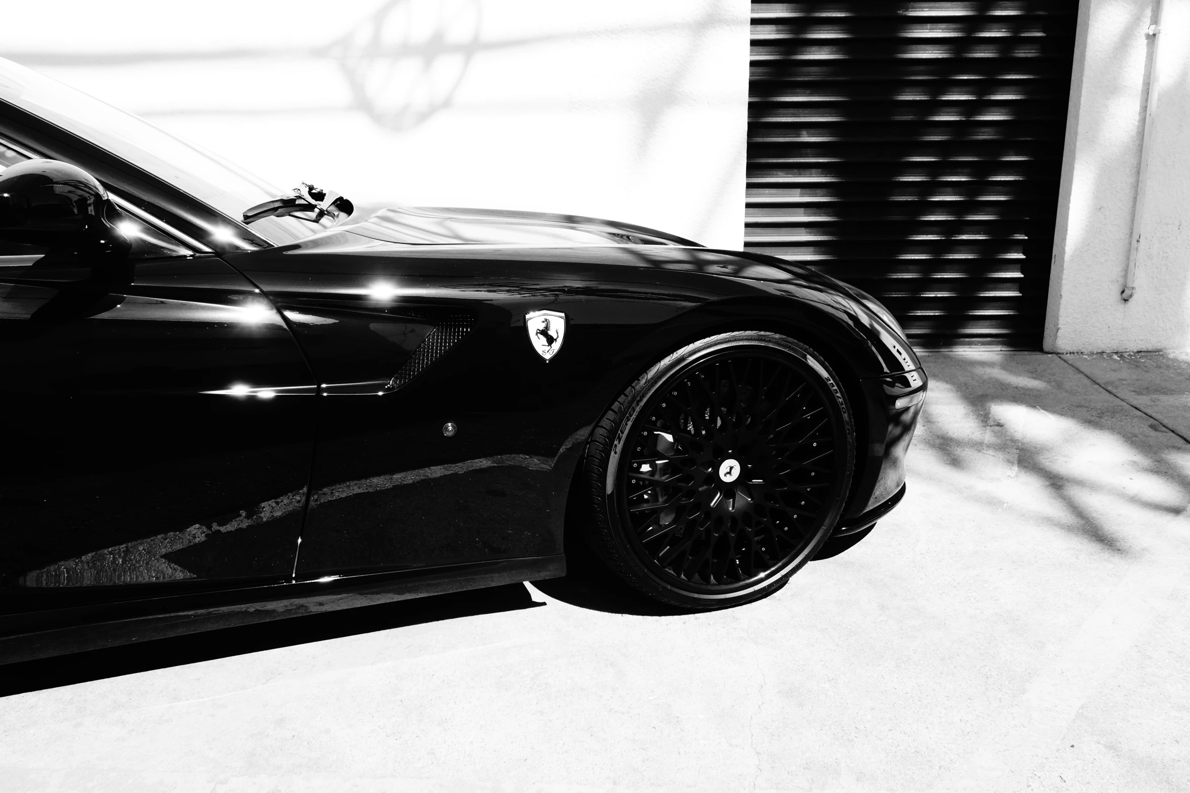 a black porsche sports car parked in front of a garage door