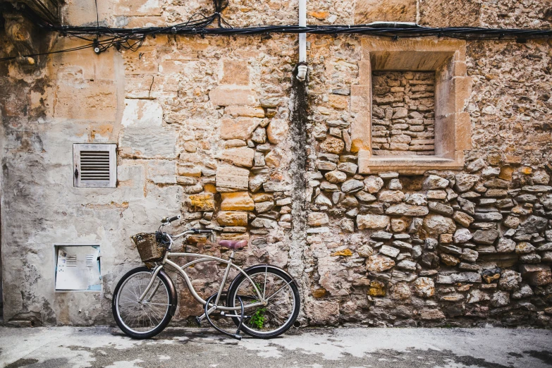 a bike parked in front of a stone wall