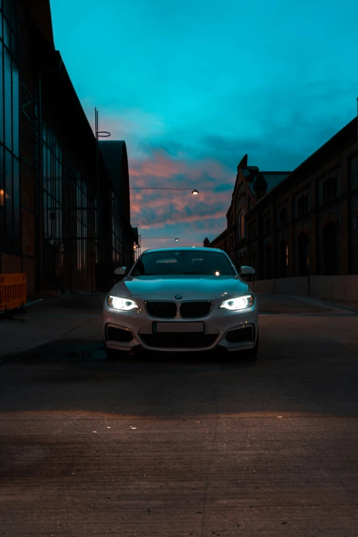 a white car parked on the street at dusk