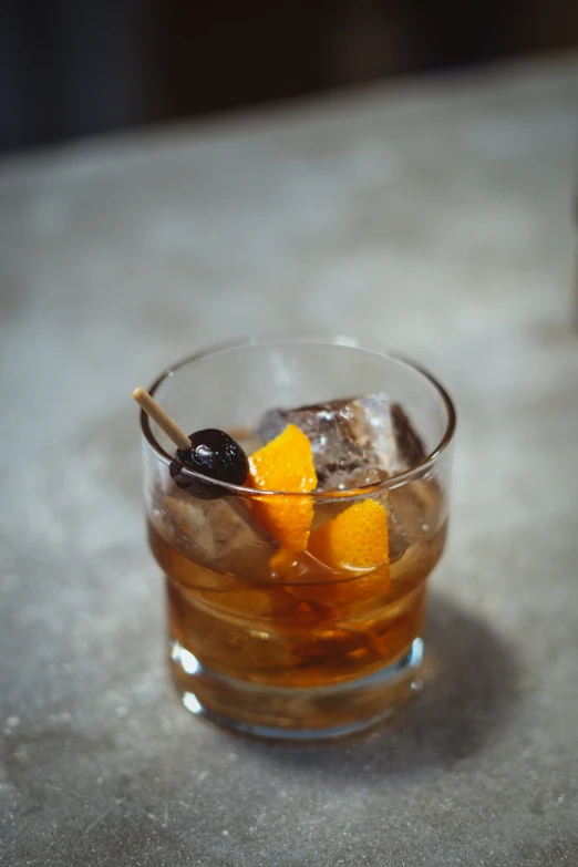 a drink sits on the table with ice and fruits