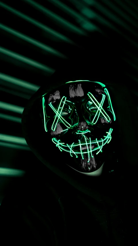 a person in a black hoodie with neon green lights on his face