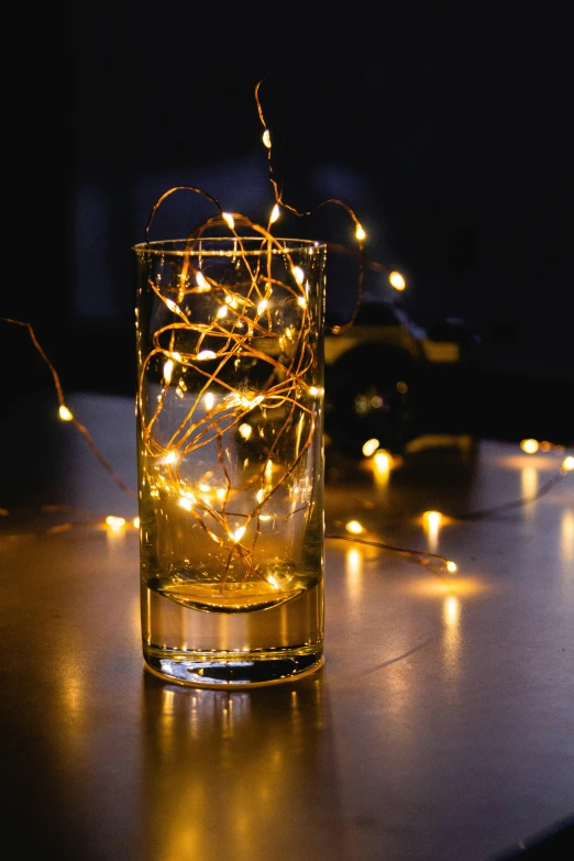 some light strings in a glass filled with water