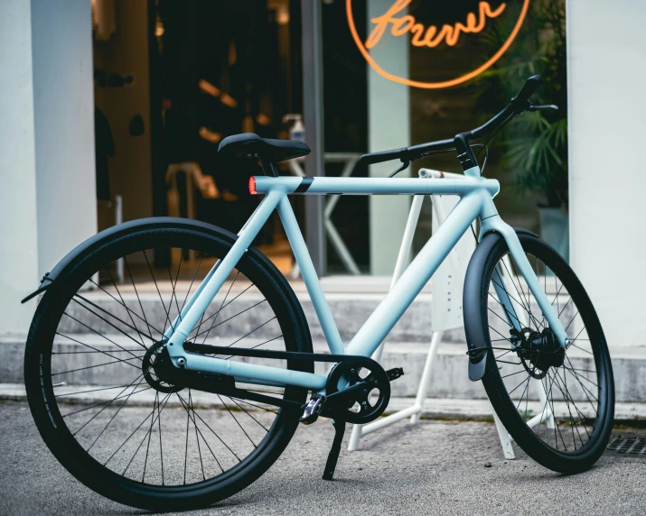 a light blue bike parked in front of a store