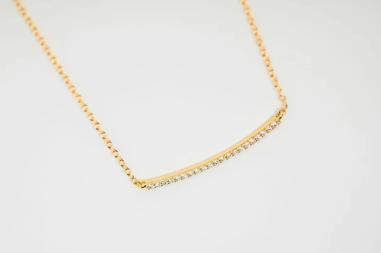 the long gold necklace with diamonds hangs on a chain