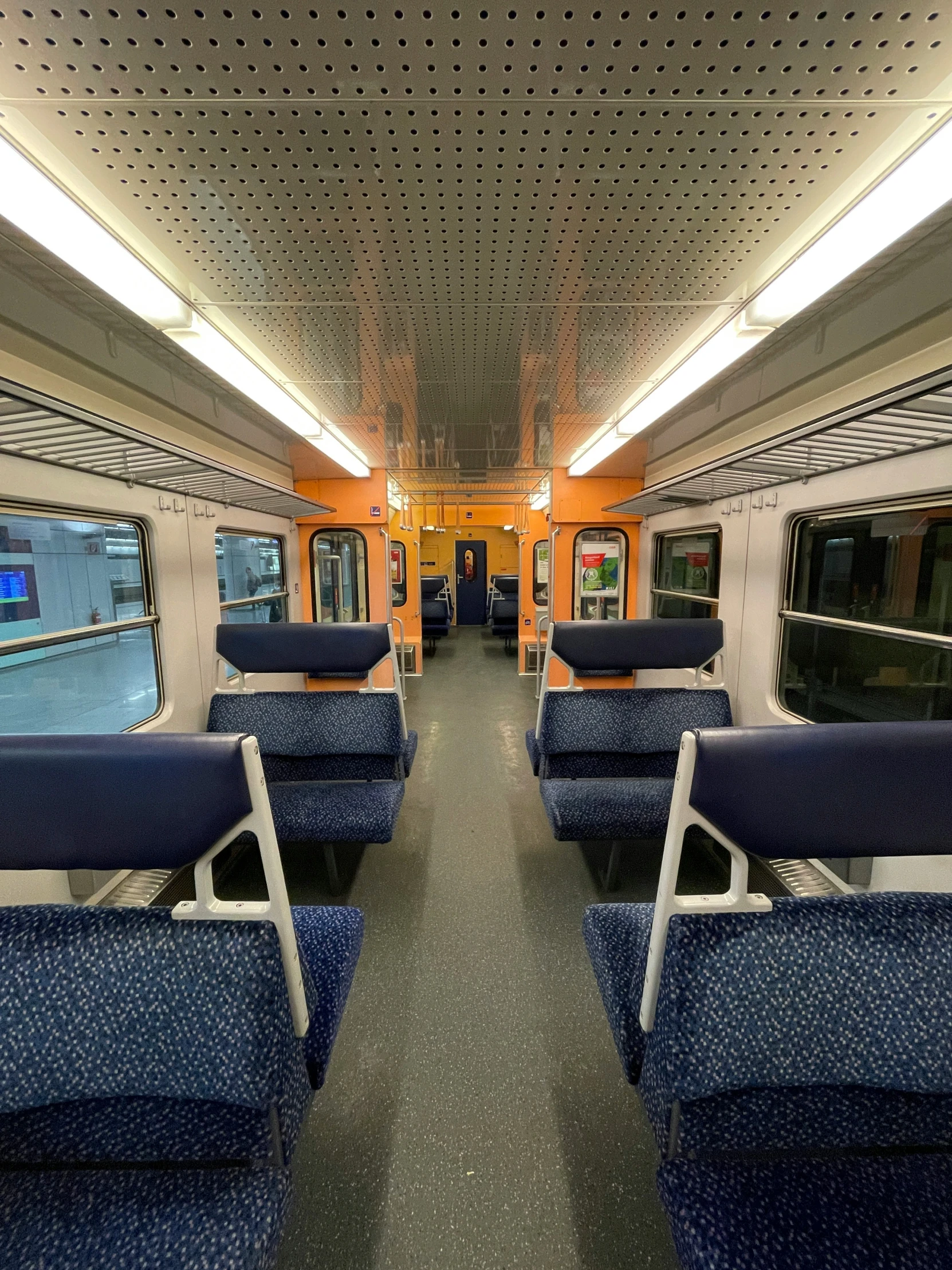 the interior of a metro train showing seats with blue and white covers