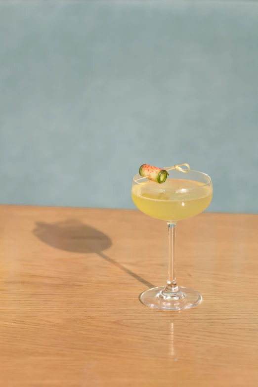 a yellow wine glass with a drink sitting on a table