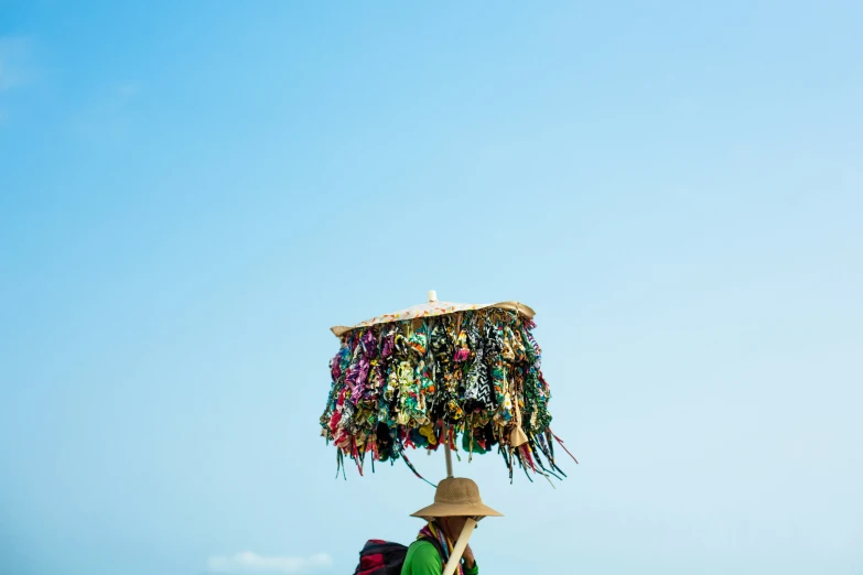 a woman is sitting in a chair under a hat and beads