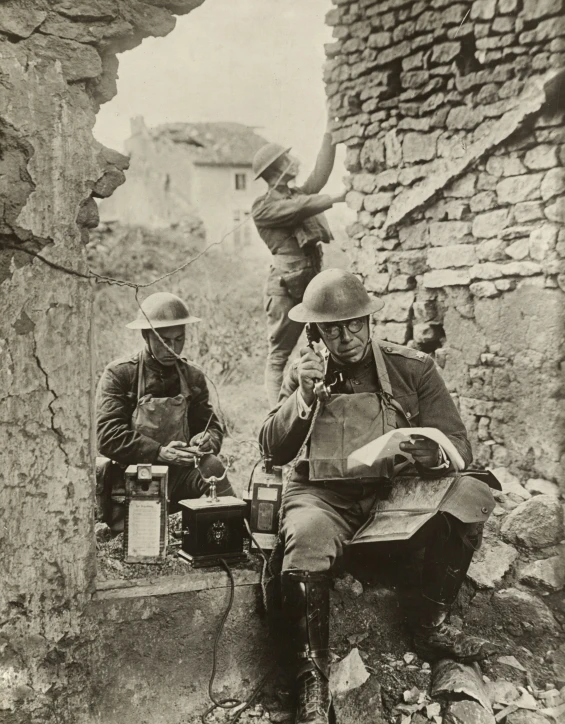 three men in military uniforms sitting in the ruins