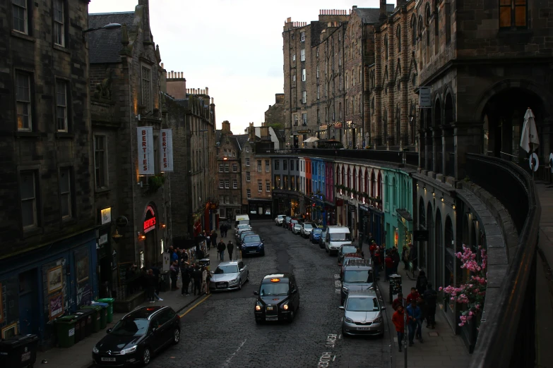 a street scene with several parked cars near many buildings