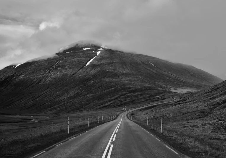 a black and white pograph of the road leading to some mountains