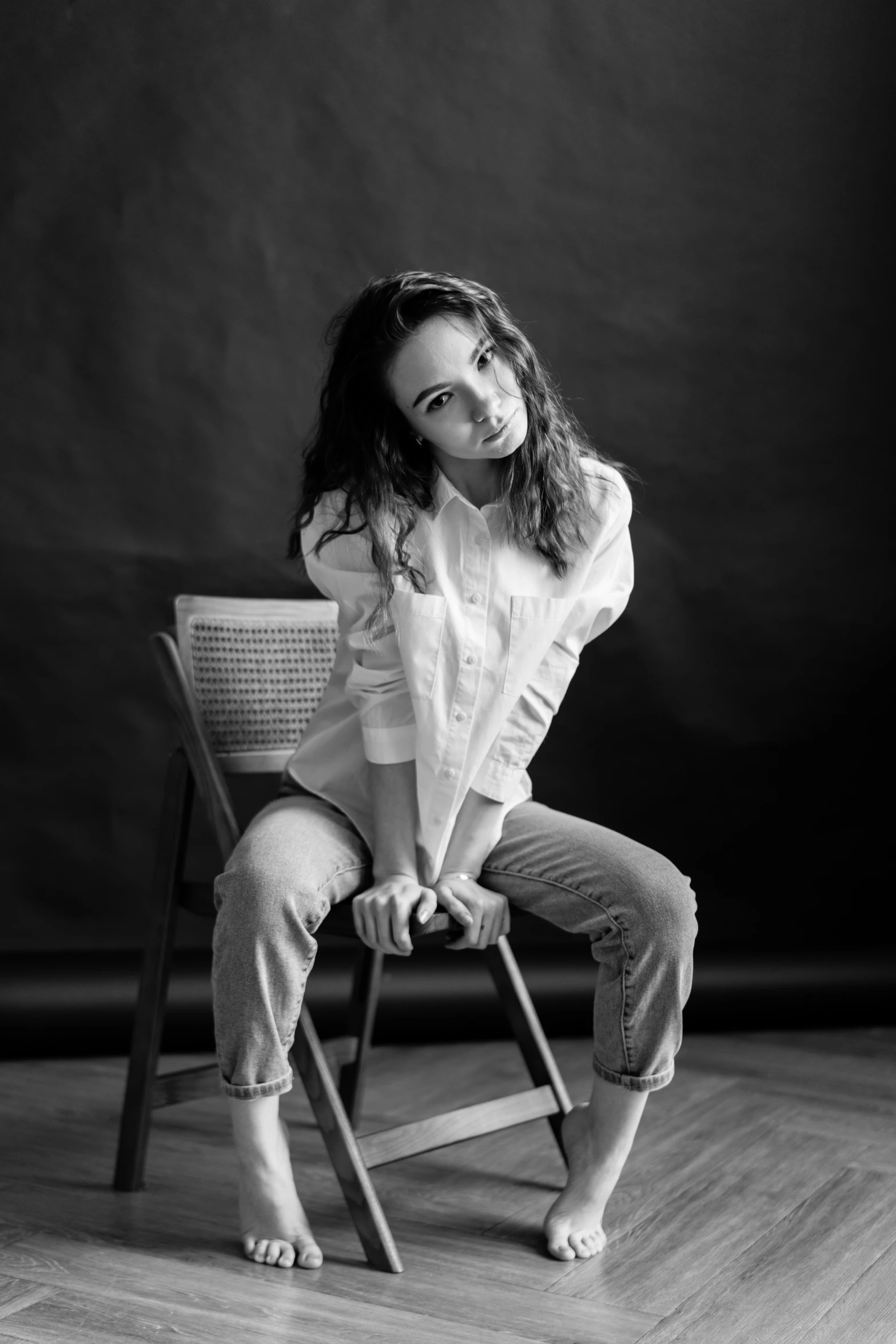 a woman sitting on top of a wooden chair