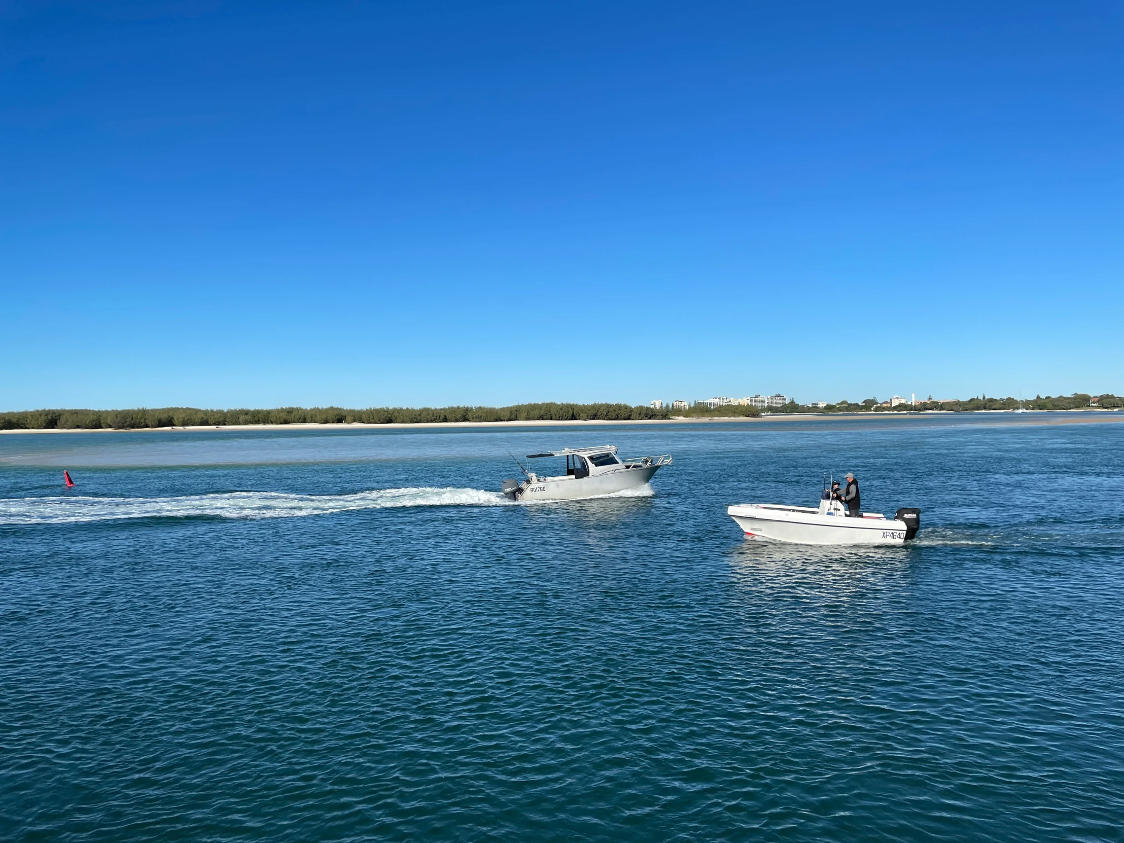 two boats traveling on the ocean, near one another