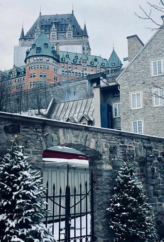 the gate to a very old stone building in winter