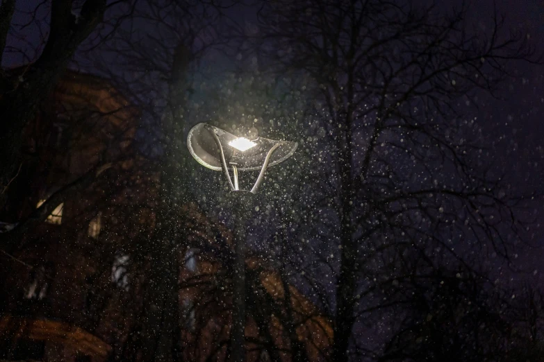 the streetlight shines brightly in front of some trees