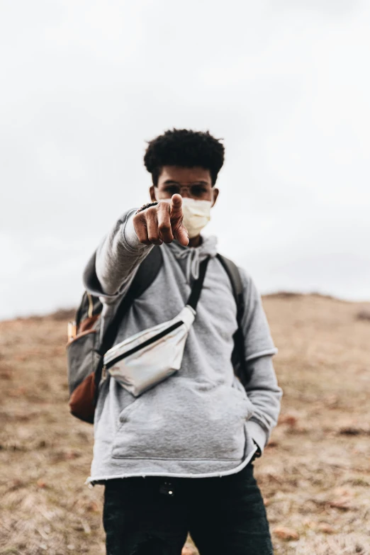 man in grey sweater taking pograph with camera bag