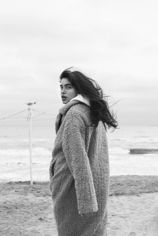 a woman standing on the beach by herself