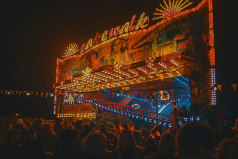 a brightly lit neon sign above a crowd at night