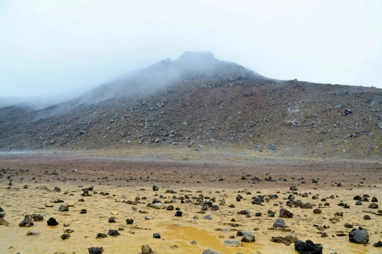 the mountain is covered with fog and rocks