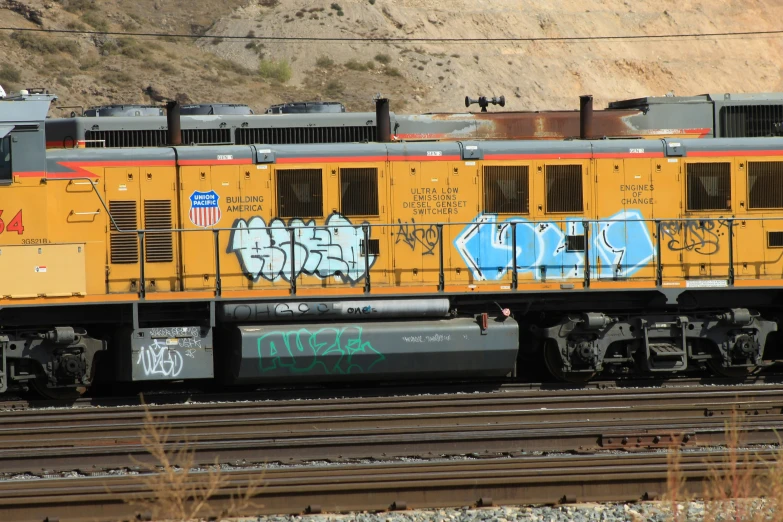 a train with graffiti is on the tracks