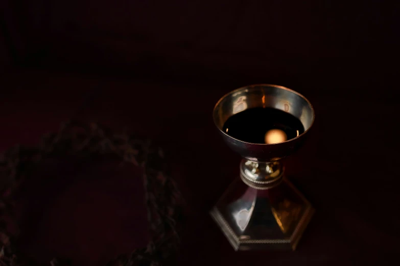 an empty bowl of liquid in a small silver stand