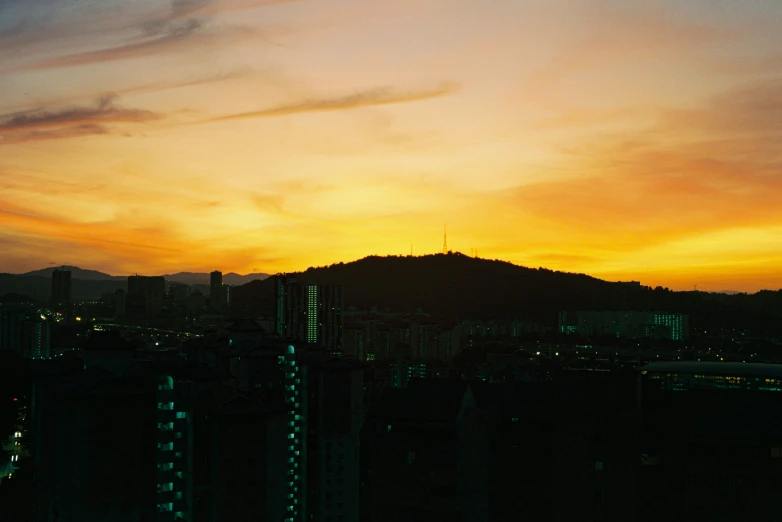 a city skyline is silhouetted by the sunset