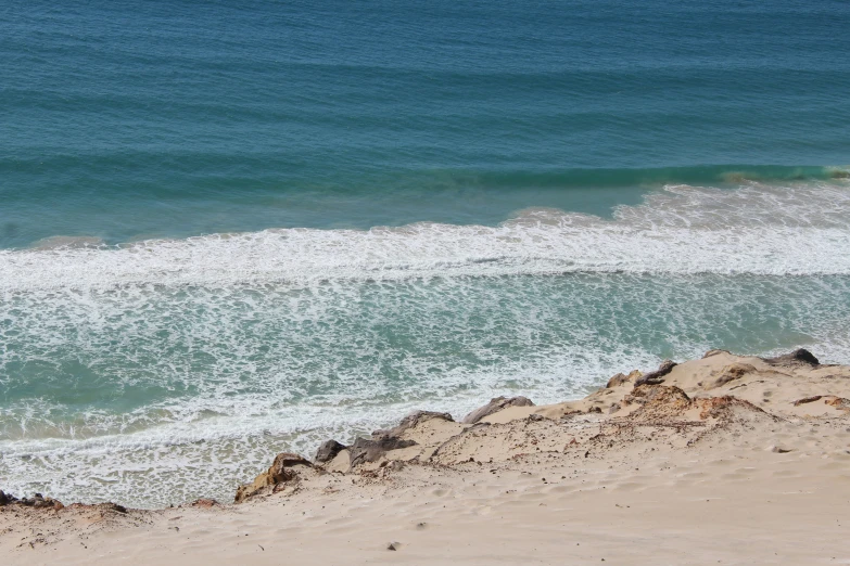 a surfer in a wetsuit riding a wave in the ocean