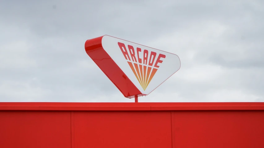 the sign shows an arrow that is on top of a red building