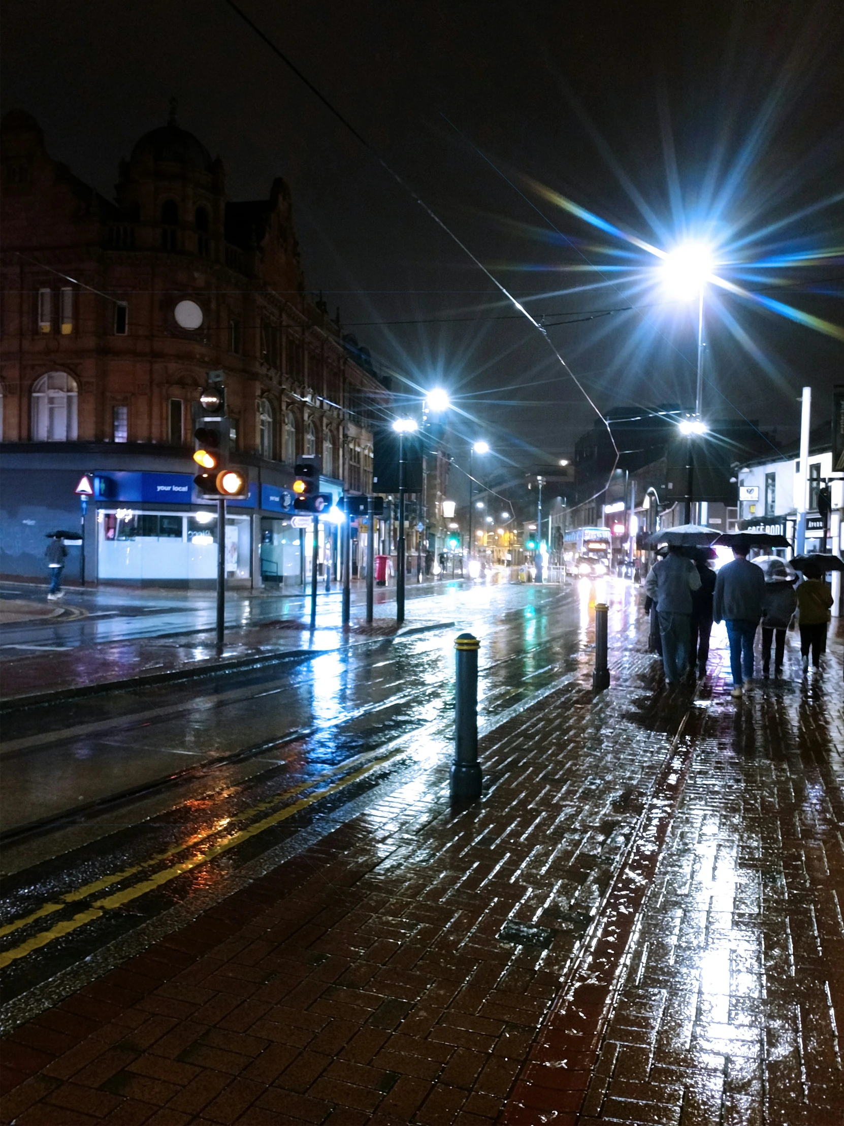 people standing on the street in the rain