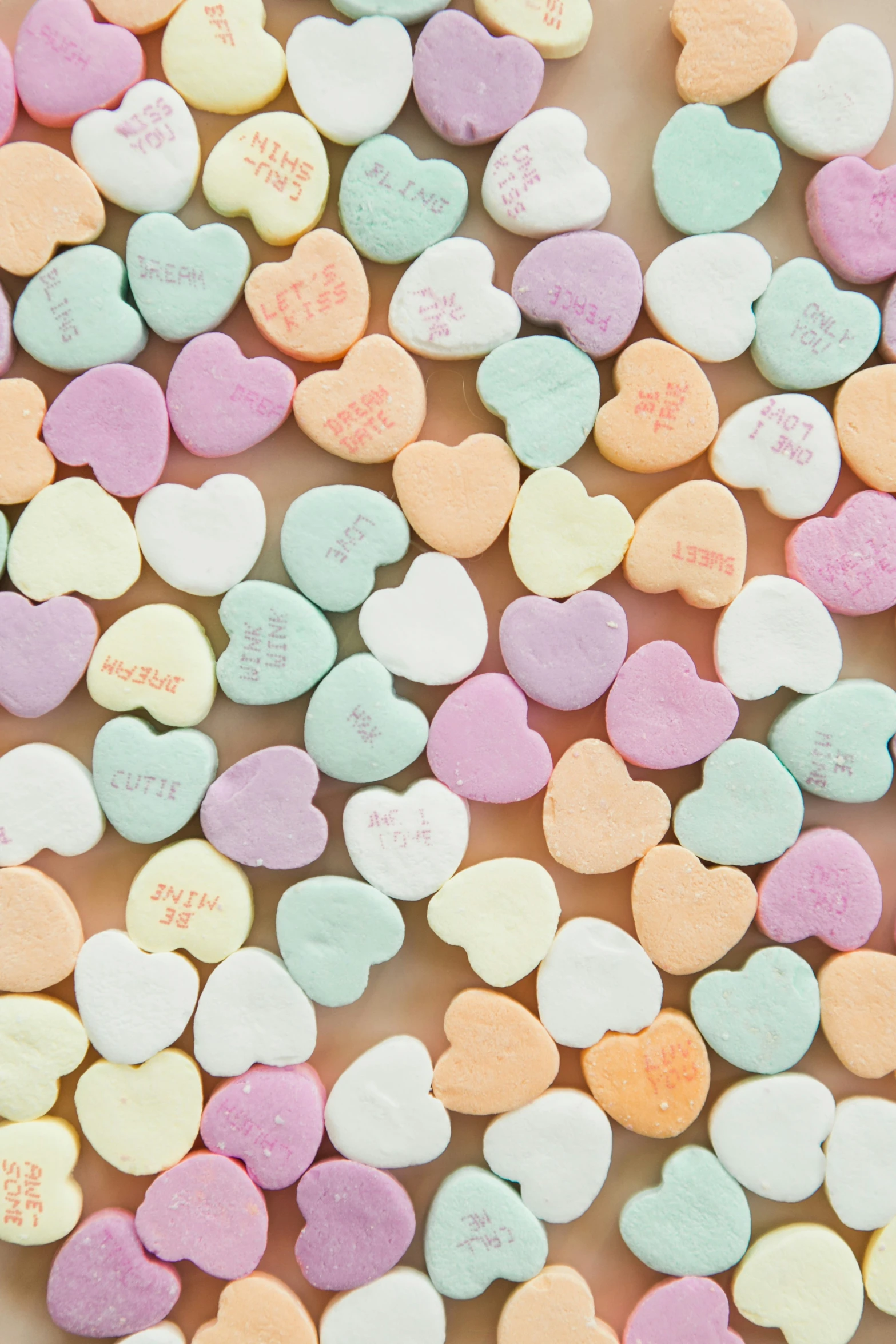 lots of heart shaped candy on a brown plate