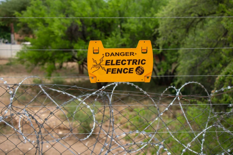 a sign is posted on a barbed wire fence