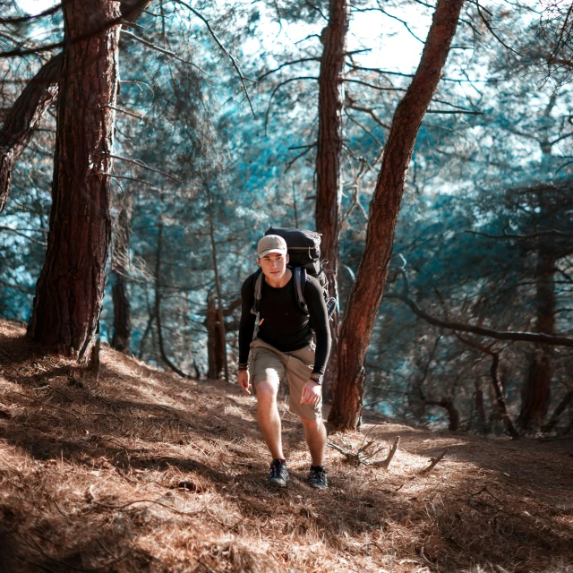 a male hiker with a backpack walks up a hill