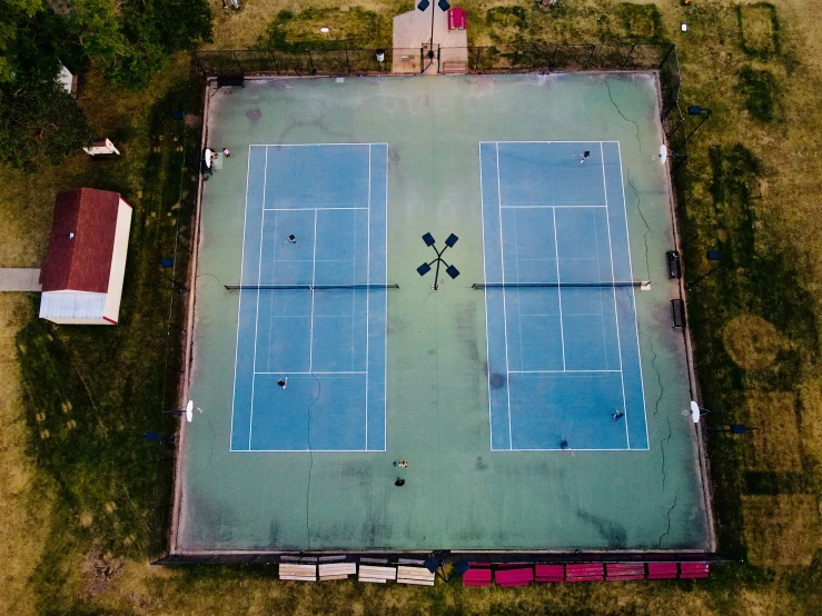 aerial view of several tennis courts in the grass