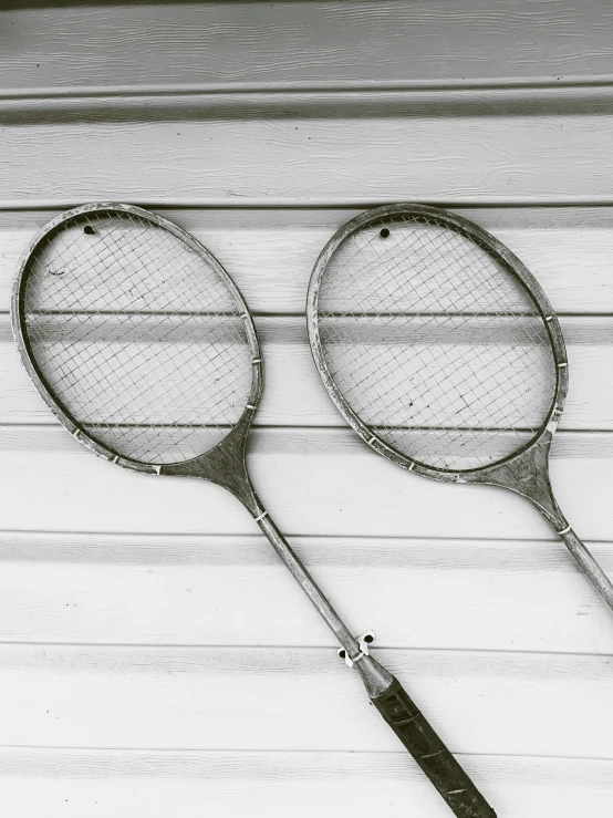 two vintage tennis rackets on top of a wooden table