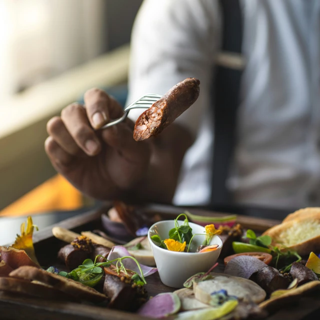 a person getting food from a plate while eating