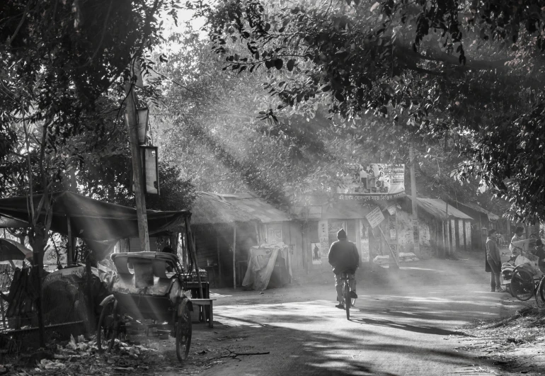 man on bicycle in countryside setting in black and white