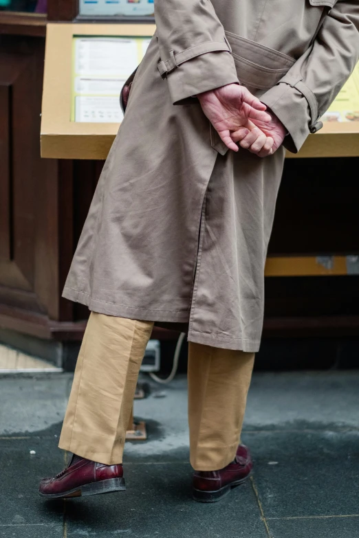 an older gentleman standing with his hand in the pocket of his coat