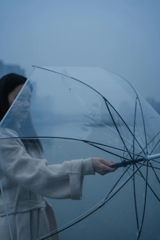 a person holding an umbrella in a foggy scene