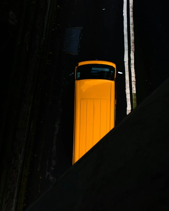 a long yellow car that is parked at night