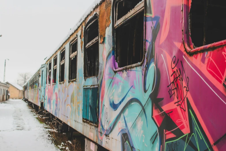 graffiti painted on a train traveling by a building