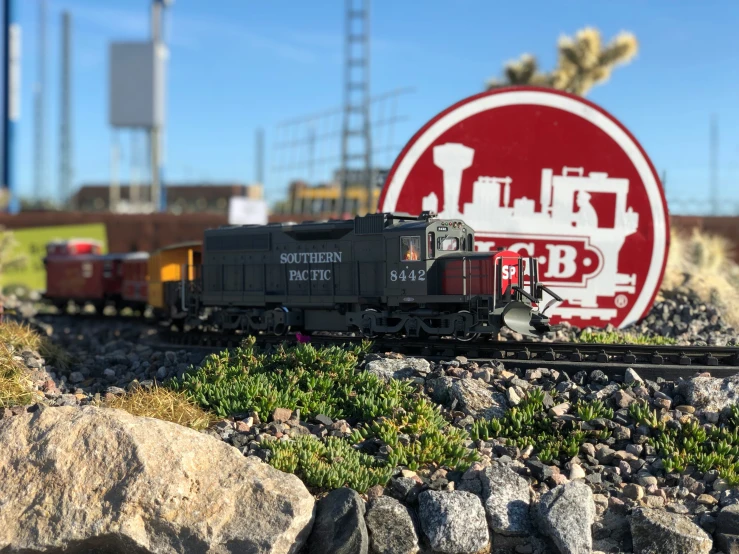 train going through a small model desert with a sign