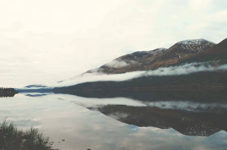 a reflection of clouds in the water on a mountain