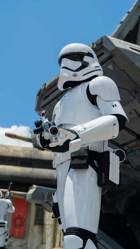 a star wars themed storm trooper posed in front of a large object