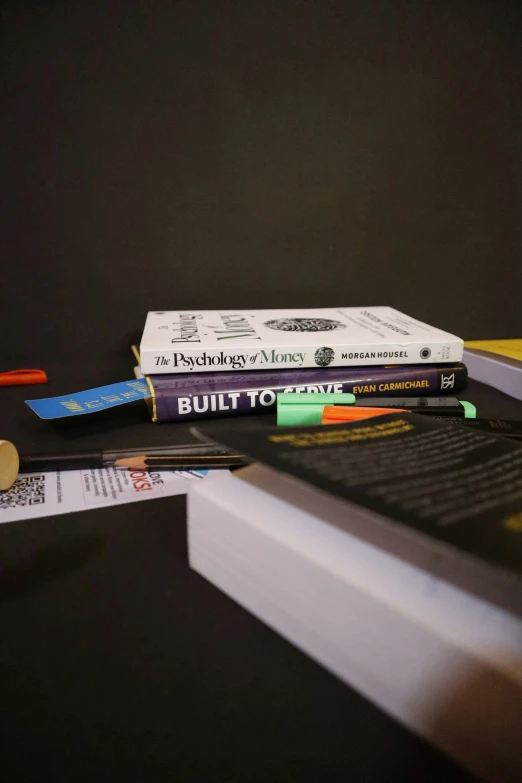 a stack of books and pens resting on a table