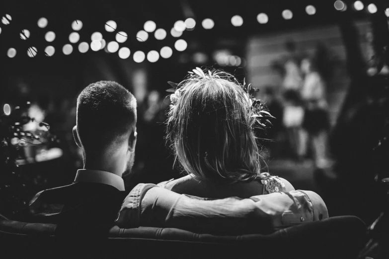 the back of two people sitting in front of a crowd