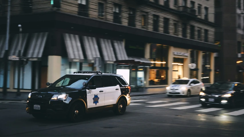 a police suv driving down a street in front of tall buildings