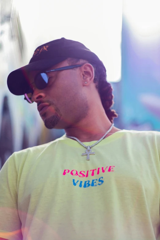 the man is wearing a tee shirt that says positive vibes on it