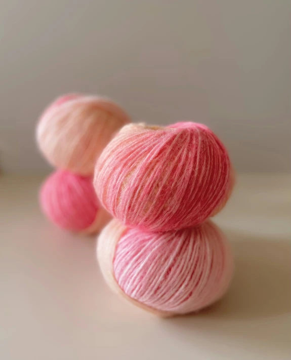 four balls of pink yarn lined together